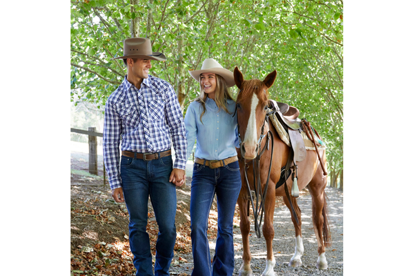 Couple dressed in Country Clothing with a saddled horse